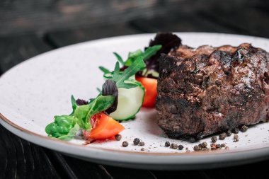 Izgara dana biftek salata koyu ahşap arka plan üzerinde