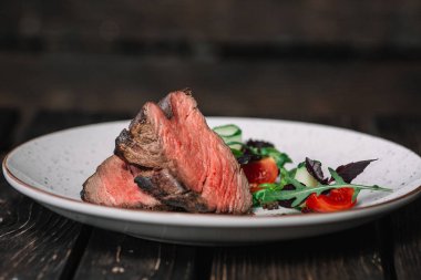 Izgara dana biftek salata koyu ahşap arka plan üzerinde