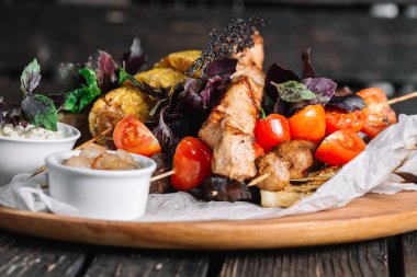 Cracklings ve brynza koyu ahşap arka plan üzerinde ahşap bir gemide ile çeşitli lezzetli ızgara et sebze ile servis