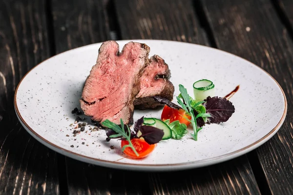 Izgara dana biftek salata koyu ahşap arka plan üzerinde