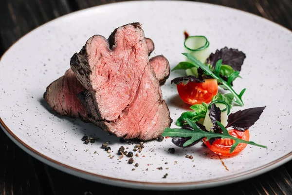 Izgara dana biftek salata koyu ahşap arka plan üzerinde