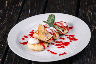 ottage krep ekşi krema ve koyu ahşap arka plan üzerinde beyaz tabakta reçel ile