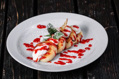 ottage krep ekşi krema ve koyu ahşap arka plan üzerinde beyaz tabakta reçel ile