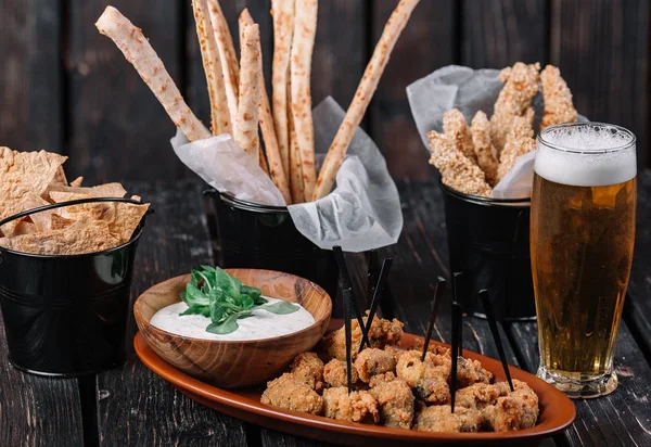 Bardak bira ve koyu ahşap arka plan snacks. Grisini, ızgara tavuk göğsü, pide cips