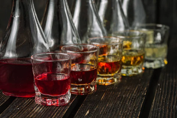 Různé Alkoholické Likéry Skleničky Karafy Tmavé Pozadí — Stock fotografie
