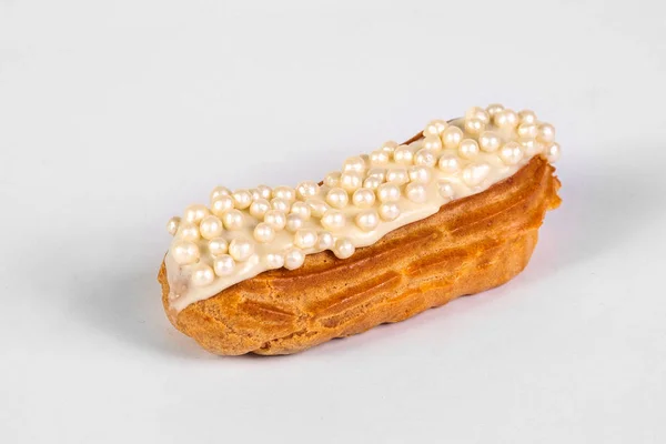 Francouzský dezert Eclair s bílou glazurou na bílém pozadí — Stock fotografie