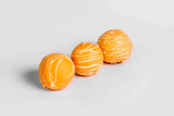 Трюфели с апельсином на белом фоне — стоковое фото