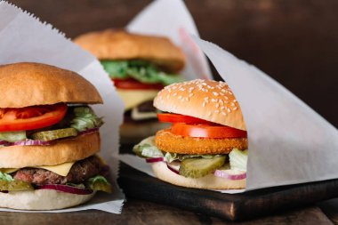 Hamburger ahşap masa üzerinde üç farklı tür