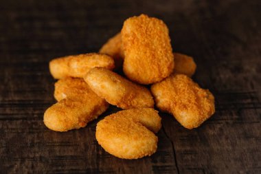 Ahşap arka planda kızarmış tavuk nugget.