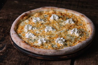 Quattro formaggi pizza ahşap arka plan üzerinde kesme tahtası üzerinde