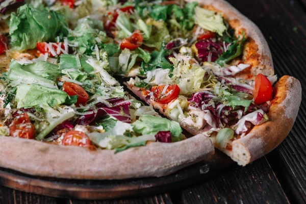Pizza with chicken and salad on wood background