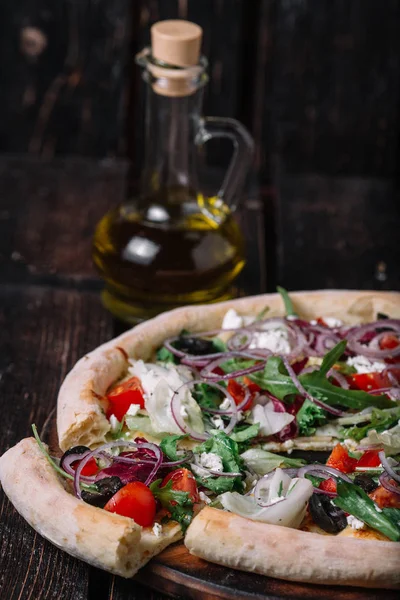 Pizza com uma fatia e uma garrafa de azeitona no bosque — Fotografia de Stock