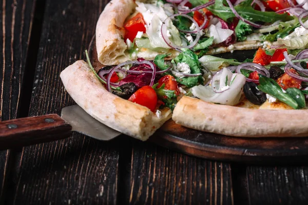 Pizza vegetariana fatiada e espátula no fundo de madeira — Fotografia de Stock