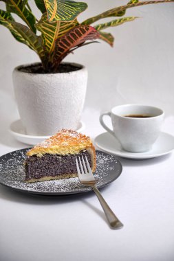 Haşhaş tohumlu pastadan tatlı üzerine krema serpiştirilmiş şeker ve bir küp