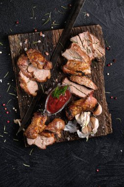 Biberiyeli taze şiş kebap ve tahta kesme tahtasında iki çeşit sos. Siyah arka planda. Üst görünüm