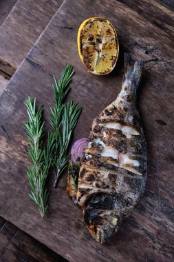 Izgara Dorado bir kesme tahtasında servis edilir. Ahşap arka planda. Üst görünüm