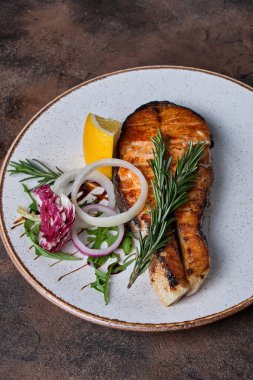 Siyah arka planda beyaz tabakta ızgara somon.