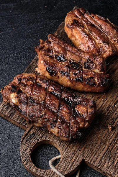 Koyu beton arka planda kesilmiş domuz pirzolası.