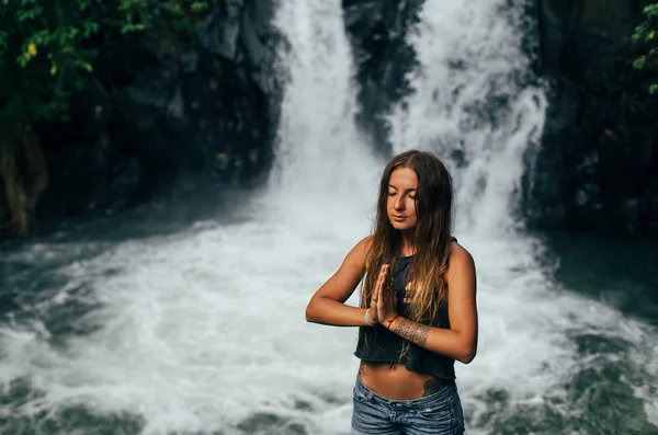 Mädchen meditiert in der Nähe von Wasserfall — Stockfoto