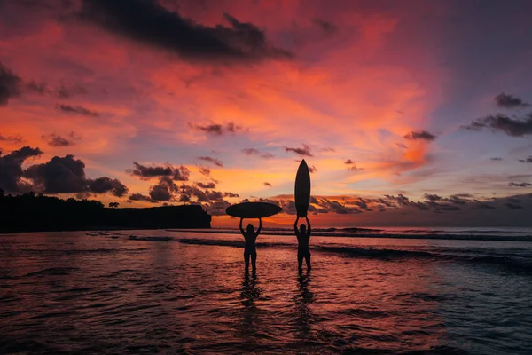 Surfer girls at sunset — Stock Photo, Image