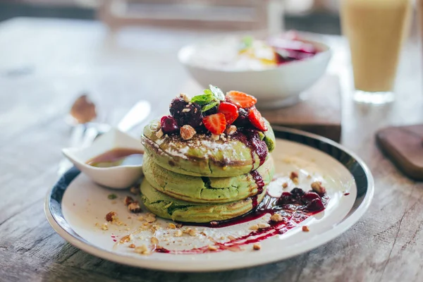 Green pancakes with berries on top — Stock Photo, Image