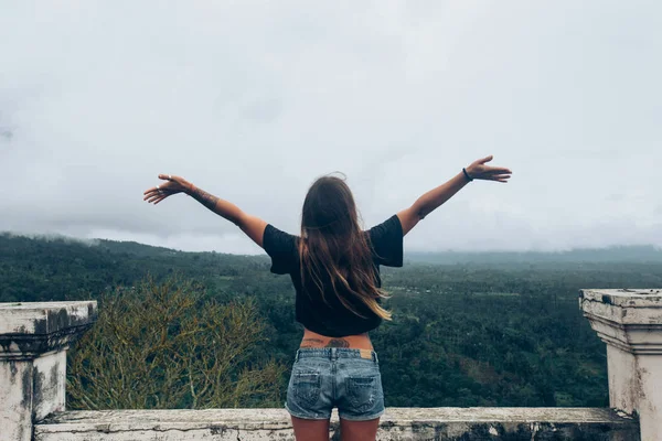 Mujer con los brazos levantados de pie al aire libre —  Fotos de Stock