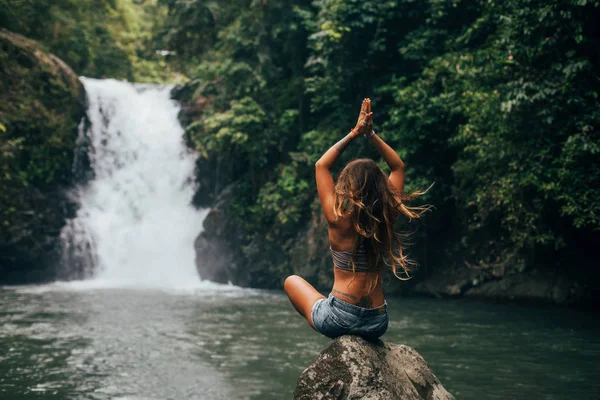 Chica medita cerca de cascada — Foto de Stock