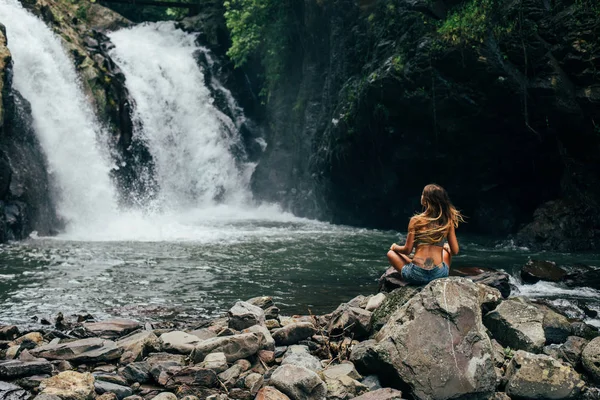 Lány meditál vízesés közelében — Stock Fotó