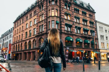 Genç kız şehirde yürüyüş arka görünümü