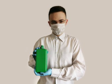 Sağlık görevlisinin elinde bir şişe antiseptik var.