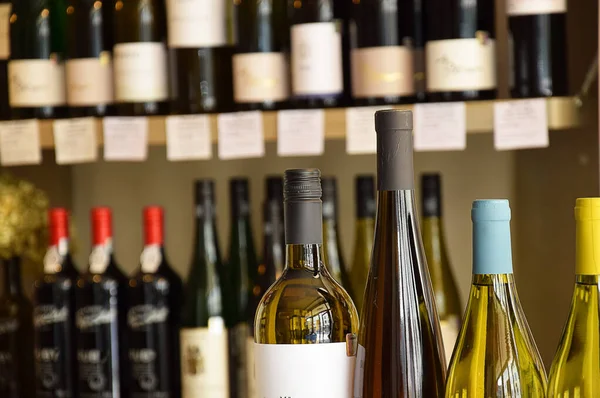 Wine bottles on wooden shelf in wine store