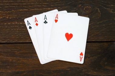 İskambil poker oyunu texas eski ahşap masa kavramı üzerinde üç as. Dört tür bir as. Ahşap arka plan casino şans. Risk başarı servet fikir vintage mobilya.