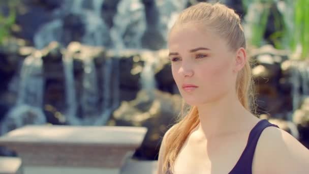 Woman portrait outdoor. Young woman posing near waterfall — Stock Video