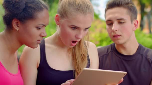 Jovens amigos lendo más notícias no tablet. Encerramento dos jovens chocados — Vídeo de Stock