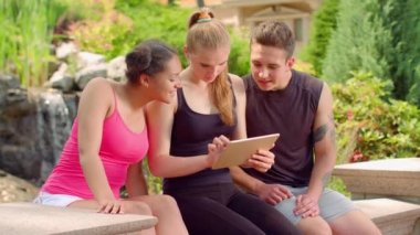 Çok kültürlü arkadaşlar dijital tablet açık okuma. Gençler tablet