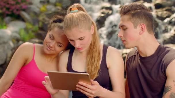 Tablet para jóvenes. Tableta de amigos. Amigos multirraciales en red al aire libre — Vídeos de Stock