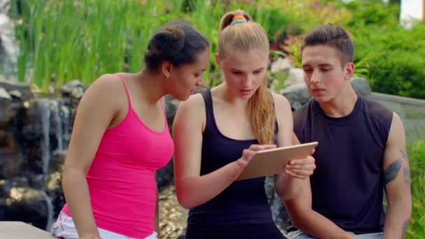 Junge Leute lesen Nachrichten auf Tablets. schockierte Menschen — Stockvideo