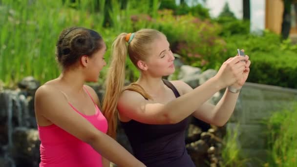 Dos chicas haciendo muecas al tomar fotos con el teléfono. Autorretrato — Vídeos de Stock