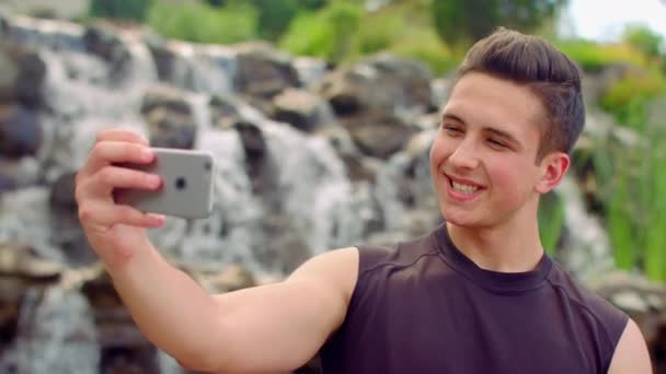 Selfie gay. Hombre gay tomando selfie en el parque. Caucásico hombre tomando fotos con el teléfono — Vídeo de stock