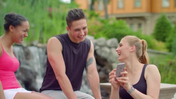 Multiraciale mensen met plezier gebruik van telefoon in park. Jonge vrienden lachen — Stockvideo