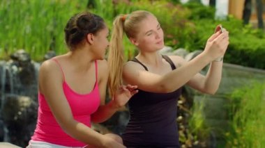 Mutlu kız parkta smartphone ile fotoğraf çekme. Selfie arkadaşlar açık havada