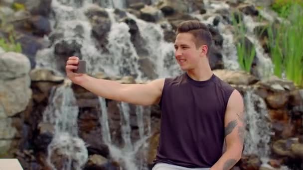 Gay prenant selfie près d'une cascade. Homme posant pour selfie photo extérieur — Video
