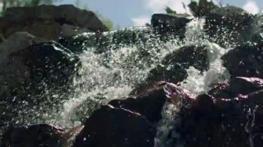 Ağır çekimde su sıçramalarına. Şelale closeup. Su sıçramalarına