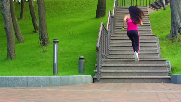 Dívka běží nahoru po schodech v parku. Žena po schodech. Mladá žena běžela nahoru — Stock video