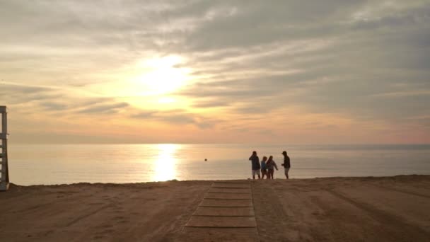 Gente parada en la playa del atardecer — Vídeo de stock