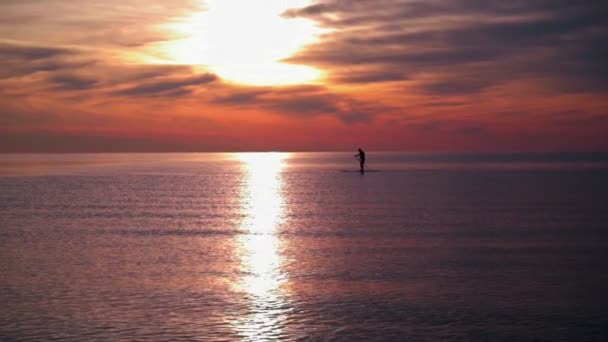 Homme sur planche de surf au coucher du soleil — Video