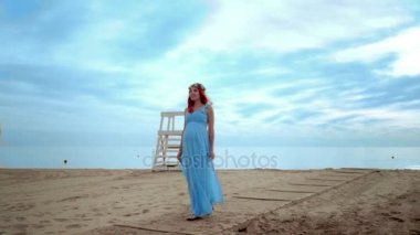 Hamile kadın kocası doğru kumsalda güneş doğarken yürüme.