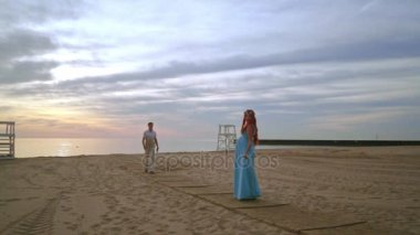 Hamile karısını doğru yürüyen adam. Sahilde romantik Fotoğraf oturumu