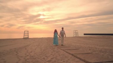 Aşk kaç gün batımında deniz Sahilde yürüyüş. Gün batımında sahilde hamile Çift