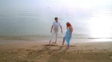 Çift kum üzerinde kalp simgesini çizin. Romantik Çift sahilde kalp şekli çizim